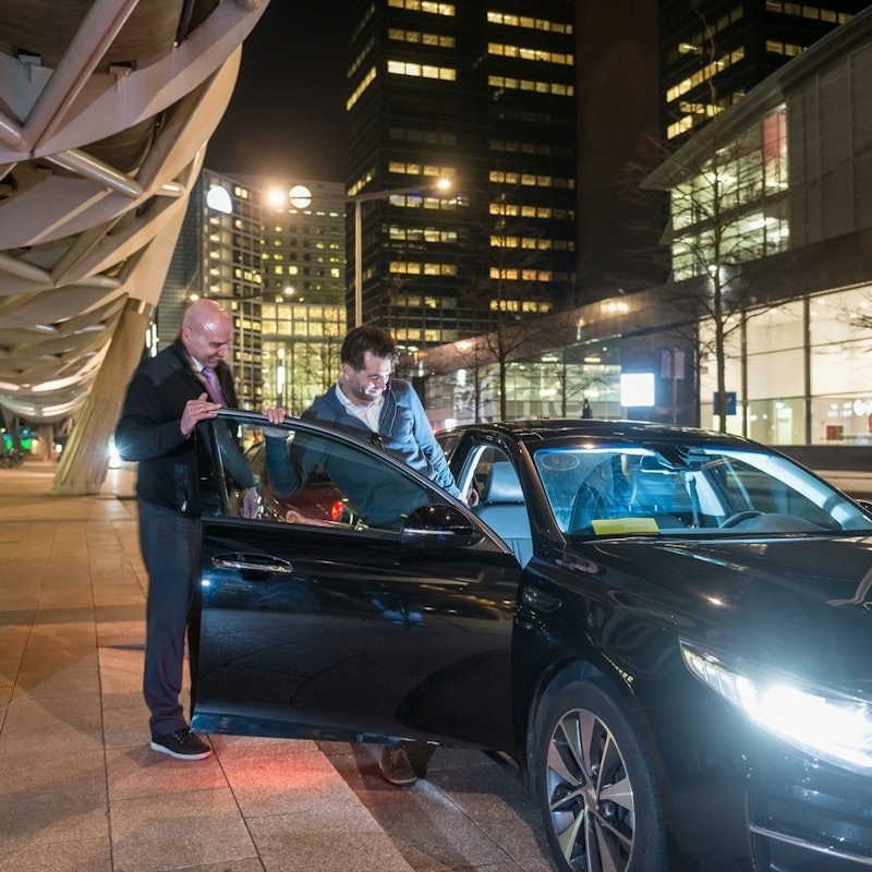 Passenger boards a private car traveling from Barcelona Airport to the city center.